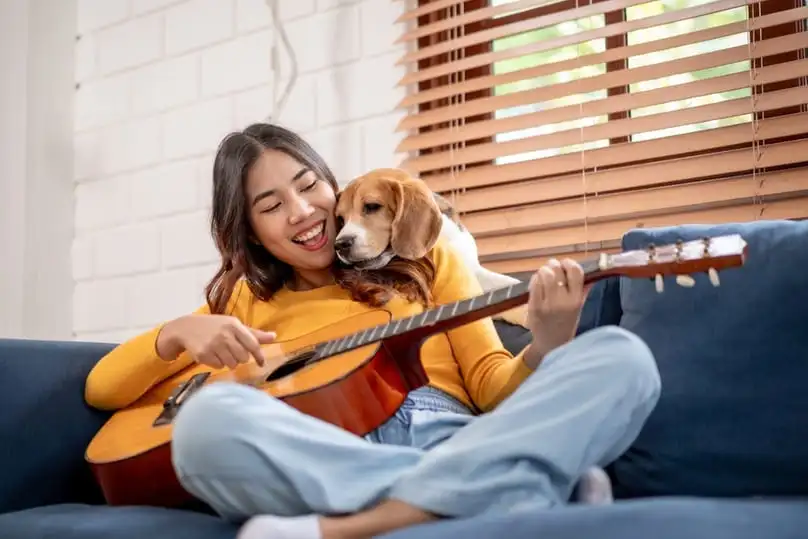 A happy woman and her dog in a tidy living room, showing how to keep your house clean with dogs.
